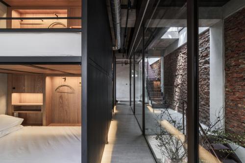 two views of a bedroom and a living room at 德旅店 Dehostel in Pingtung City