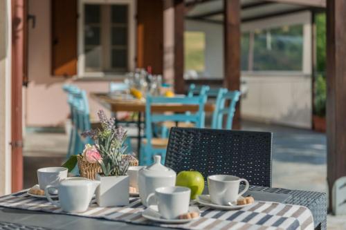 a table with coffee cups and fruit on it at Villa Rosa in Fossombrone