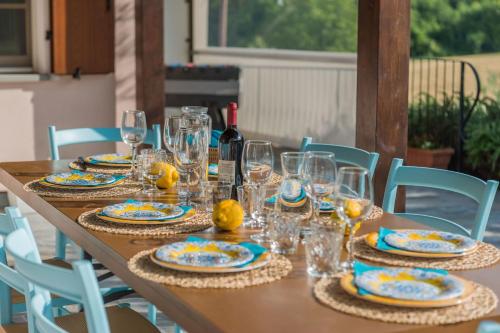 a table with glasses and plates and a bottle of wine at Villa Rosa in Fossombrone