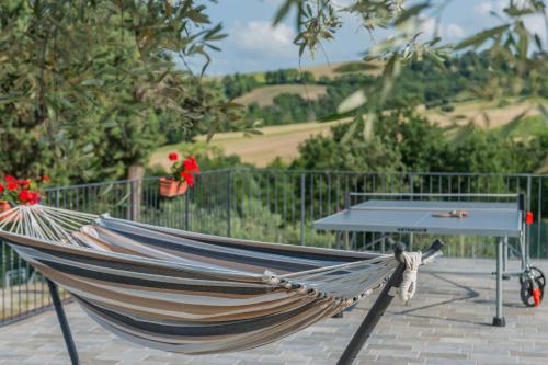 a hammock in front of a table and a fence at Villa Rosa in Fossombrone