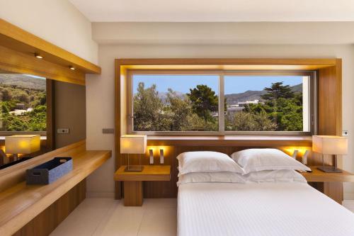 a bedroom with a white bed and a large window at Villantonella in Sorrento