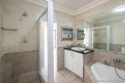 a bathroom with a tub and a sink and a shower at C302 SURFSIDE in Umdloti