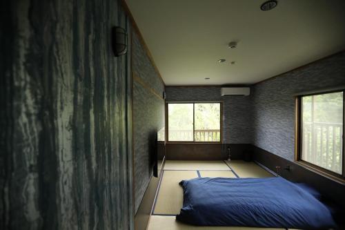 a bedroom with a blue bed and two windows at Kaira no Teitaku - Vacation STAY 63757v in Iwase