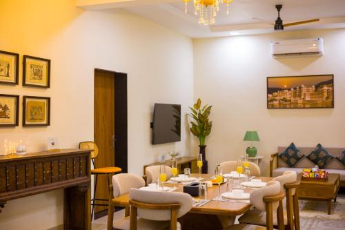 a dining room with a table and chairs at The Bliss Nestlewood 2-BHK Villa With Private Pool, Lush Garden & Poolside Gazebo in Udaipur