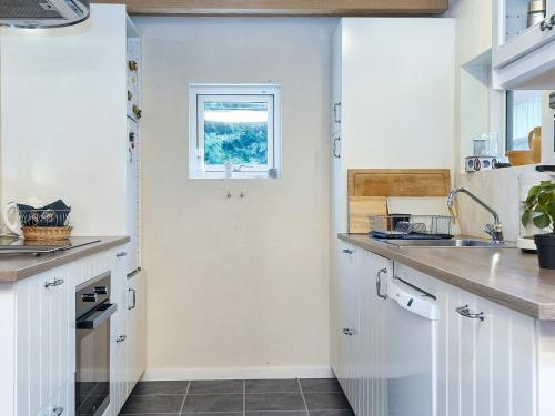 a kitchen with white cabinets and a window at 4 person holiday home in Fårvang-By Traum in Fårvang