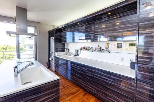 a bathroom with a large sink and a large window at Andiamo Nosoko - Vacation STAY 73186v in Ibaruma