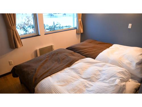 a bedroom with two beds next to a window at MUSH ROOMS - Vacation STAY 75024v in Higashikawa