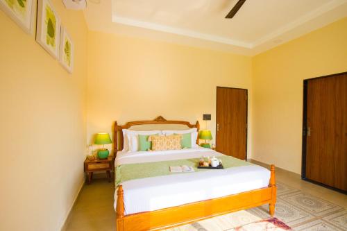 a bedroom with a large bed with yellow walls at The Bliss Nestlewood 2-BHK Villa With Private Pool, Lush Garden & Poolside Gazebo in Udaipur