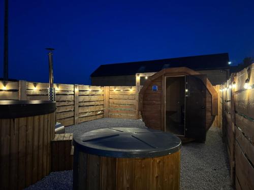 a backyard with a hot tub and a wooden fence at Wooden studies in Piotrowice