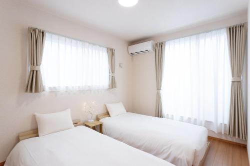 two beds in a room with a window at Genan no Sato - Vacation STAY 76405v in Odawara