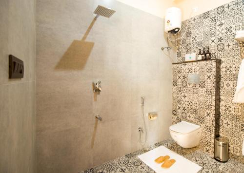 a bathroom with a shower and a toilet in it at The Bliss Nestlewood 2-BHK Villa With Private Pool, Lush Garden & Poolside Gazebo in Udaipur