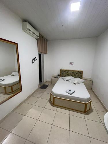 a room with a bed and a mirror in it at Hotel bom retiro in Sao Paulo