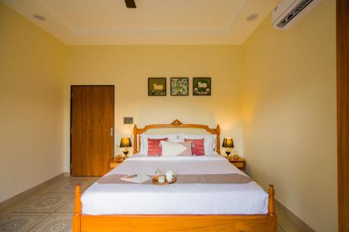 a bedroom with a large bed with a wooden headboard at The Bliss Nestlewood 2-BHK Villa With Private Pool, Lush Garden & Poolside Gazebo in Udaipur