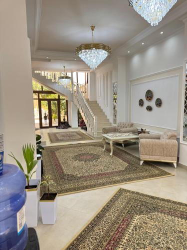 a living room with a staircase and rugs at Feruza guest house in Samarkand
