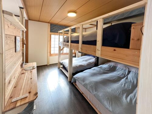 two bunk beds in a room with wooden walls at Nobotchi - Vacation STAY 87218v in Noboribetsu