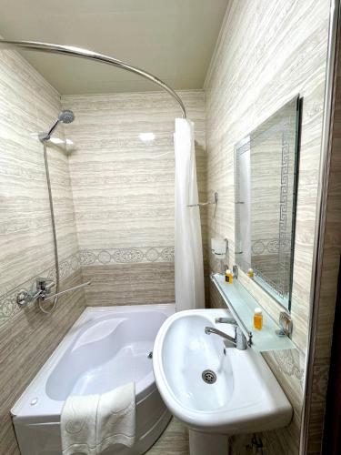 a bathroom with a white tub and a sink at Feruza guest house in Samarkand
