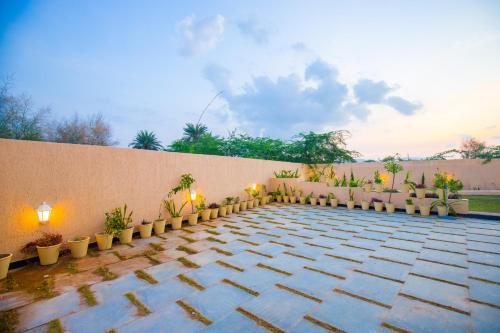 a patio with a row of chairs and plants at The Bliss Nestlewood 2-BHK Villa With Private Pool, Lush Garden & Poolside Gazebo in Udaipur