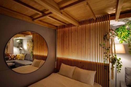 a room with a mirror and a bed and a couch at Hinata Surf Camp 108,110 - Vacation STAY 84402v in Hyuga