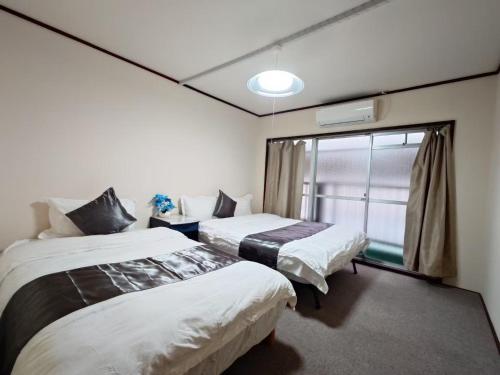 two beds in a room with a window at Mamada Building - Vacation STAY 18001 in Tokyo