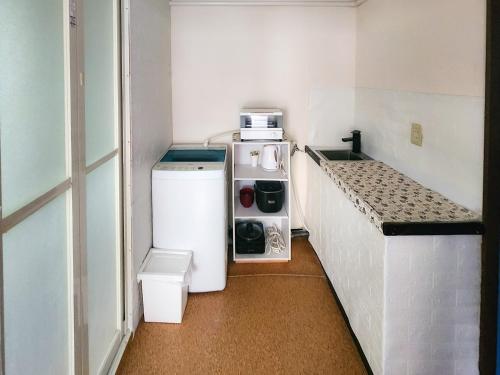 a small kitchen with a refrigerator and a counter at Mamada Building - Vacation STAY 18229 in Tokyo