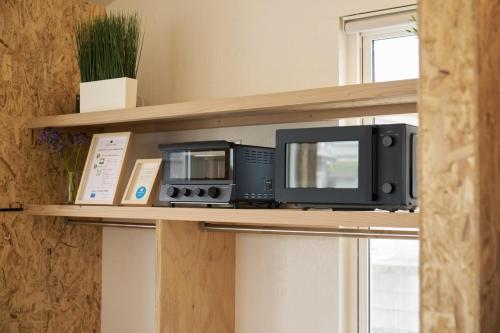 two microwaves and a microwave on a shelf at Bungalow One - Vacation STAY 98273v in Kamogawa