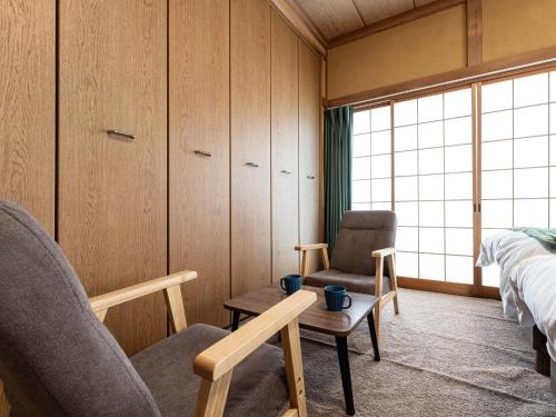 a bedroom with two chairs and a bed and a window at Ocean villa Oarai - Vacation STAY 94315v in Oarai