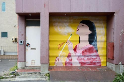 a wall with a painting of a woman holding a cigarette at Guesthouse s,e,n - Vacation STAY 99404v in Koriyama