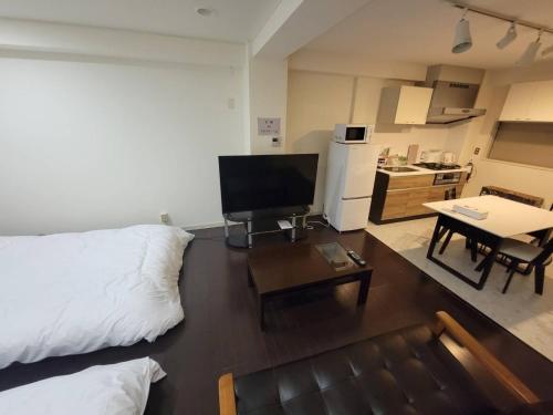 a living room with a couch and a tv and a table at Earlville - Vacation STAY 16987 in Hiroshima
