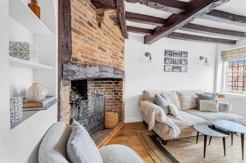 a living room with a couch and a fireplace at Dolphin Cottage in Henley on Thames
