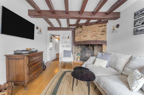 a living room with a couch and a fireplace at Dolphin Cottage in Henley on Thames