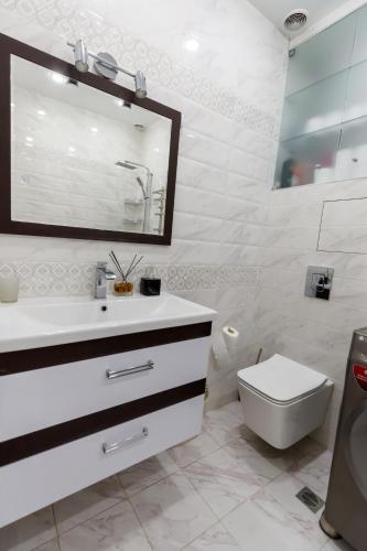 a white bathroom with a sink and a toilet at Luxury 2-Bedroom 2-Bath Apartment in City Center in Yerevan