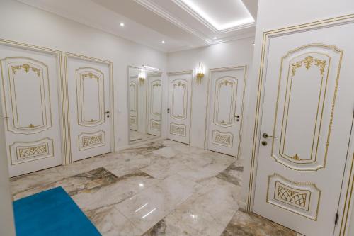 a room with white walls and gold doors at Luxury 2-Bedroom 2-Bath Apartment in City Center in Yerevan