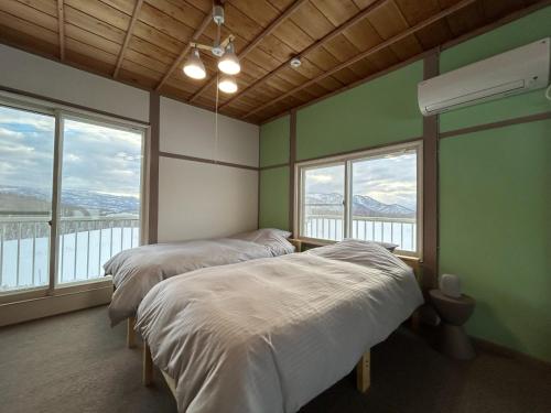 zwei Betten in einem Zimmer mit zwei Fenstern in der Unterkunft Hinode Land - Vacation STAY 06589v in Kombu