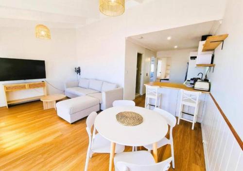 a living room with a white table and chairs at Oceanic Escape Top Floor 2 mins from beach in Perth