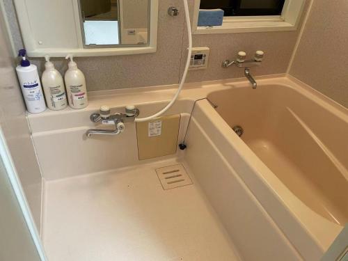 a bathroom with a bath tub and a sink at Rakuten Stay [Homelike Makuhari Hongo] - Vacation STAY 16003v in Chiba