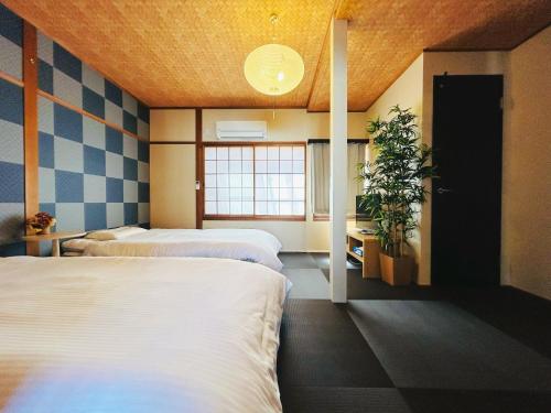 a bedroom with two beds and a potted plant at Rakuyado II - Vacation STAY 15047v in Kyoto