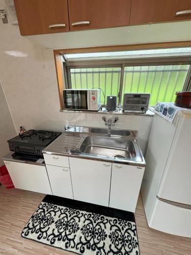 a small kitchen with a sink and a window at Bamboo Camp Site "Isumi Genji Firefly Village" - Vacation STAY 08176v in Ōtaki