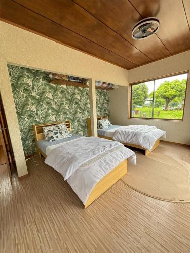 a bedroom with two beds and a wall with a mural at Bamboo Camp Site "Isumi Genji Firefly Village" - Vacation STAY 08176v in Ōtaki