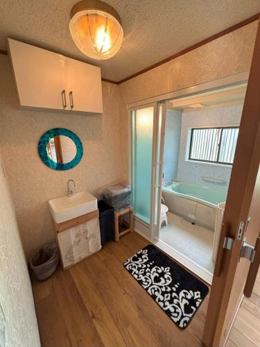 a bathroom with a tub and a sink and a mirror at Bamboo Camp Site "Isumi Genji Firefly Village" - Vacation STAY 08175v in Ōtaki
