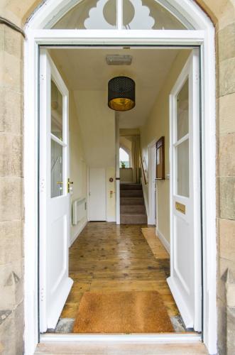 an open hallway with white doors and wood floors at Station Cottage in Bucknell