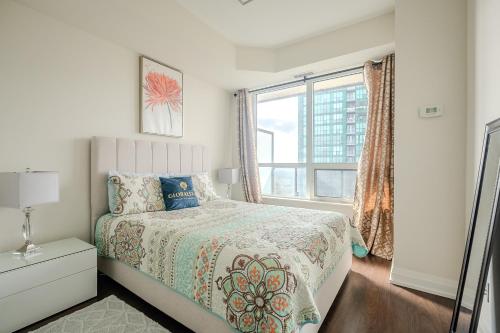 a white bedroom with a bed and a window at Modern 2Bd 2Ba Skyscraper Free parking in Toronto