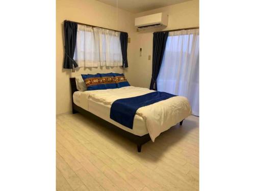 a bedroom with a bed with blue pillows and curtains at Piso Essauna - Vacation STAY 16990 in Igei