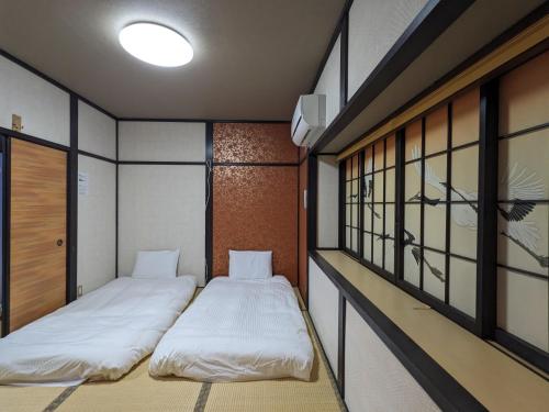 two beds in a small room with windows at Momijian Tofukuji Temple - Vacation STAY 19724v in Kyoto