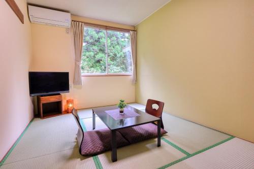 a living room with a table and a tv at Pension Yumi - Vacation STAY 20865v in Nikko