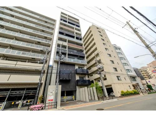 two tall buildings on a city street with a crane at ZOOM Esaka Park - Vacation STAY 17114 in Suita