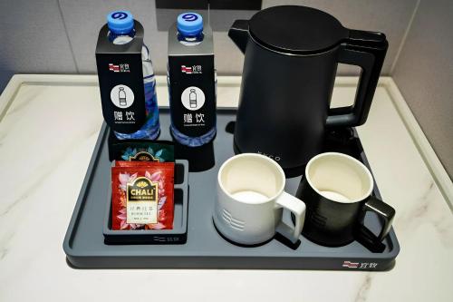 a tray with a coffee maker and cups on a counter at Yizhi Hotel - Guangzhou Shamian Island Huangsha Metro Station-Canton Fair free shuttle bus included Breakfast in Guangzhou