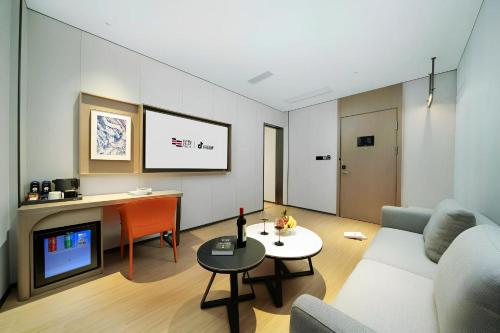 a living room with a couch and a tv at Yizhi Hotel - Guangzhou Shamian Island Huangsha Metro Station-Canton Fair free shuttle bus included Breakfast in Guangzhou
