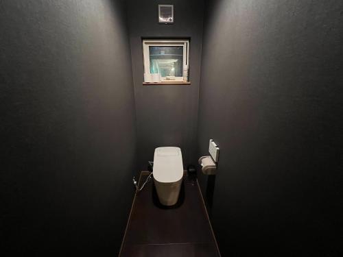 a black bathroom with a toilet and a window at casa hotel - Vacation STAY 17134 in Wakkanai