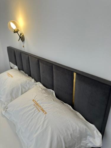 a bed with a black headboard and two white pillows at Турист in Astana