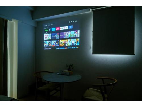 a room with a table and a tv on the wall at ZOOM Esaka Park - Vacation STAY 17110 in Suita